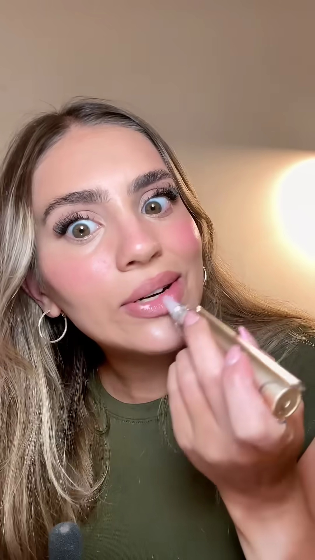 Creator squeezing the Dr. Dennis Gross lip treatment to show the product dispensing