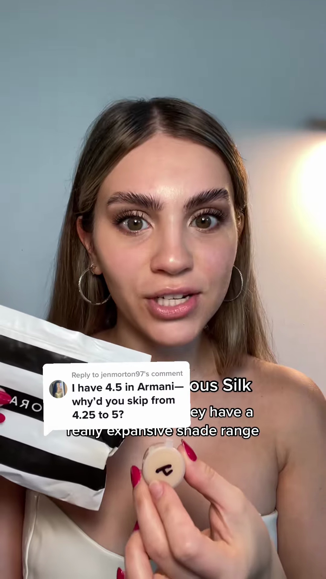 Beauty creator Bailey Martin holding Armani Luminous Silk Foundation bottle against light olive skin