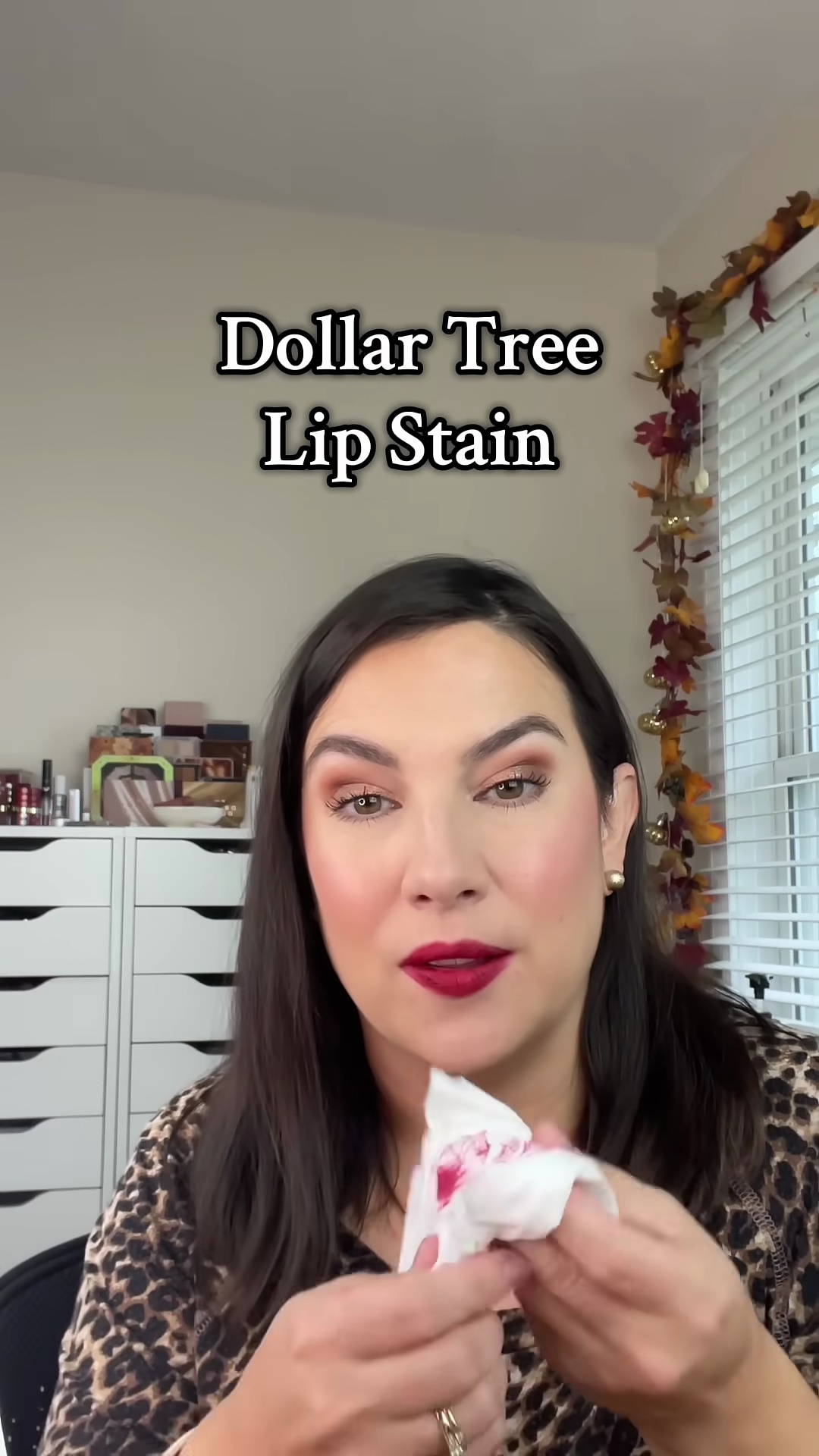 Emily blotting her lips with a tissue to remove excess lip tint