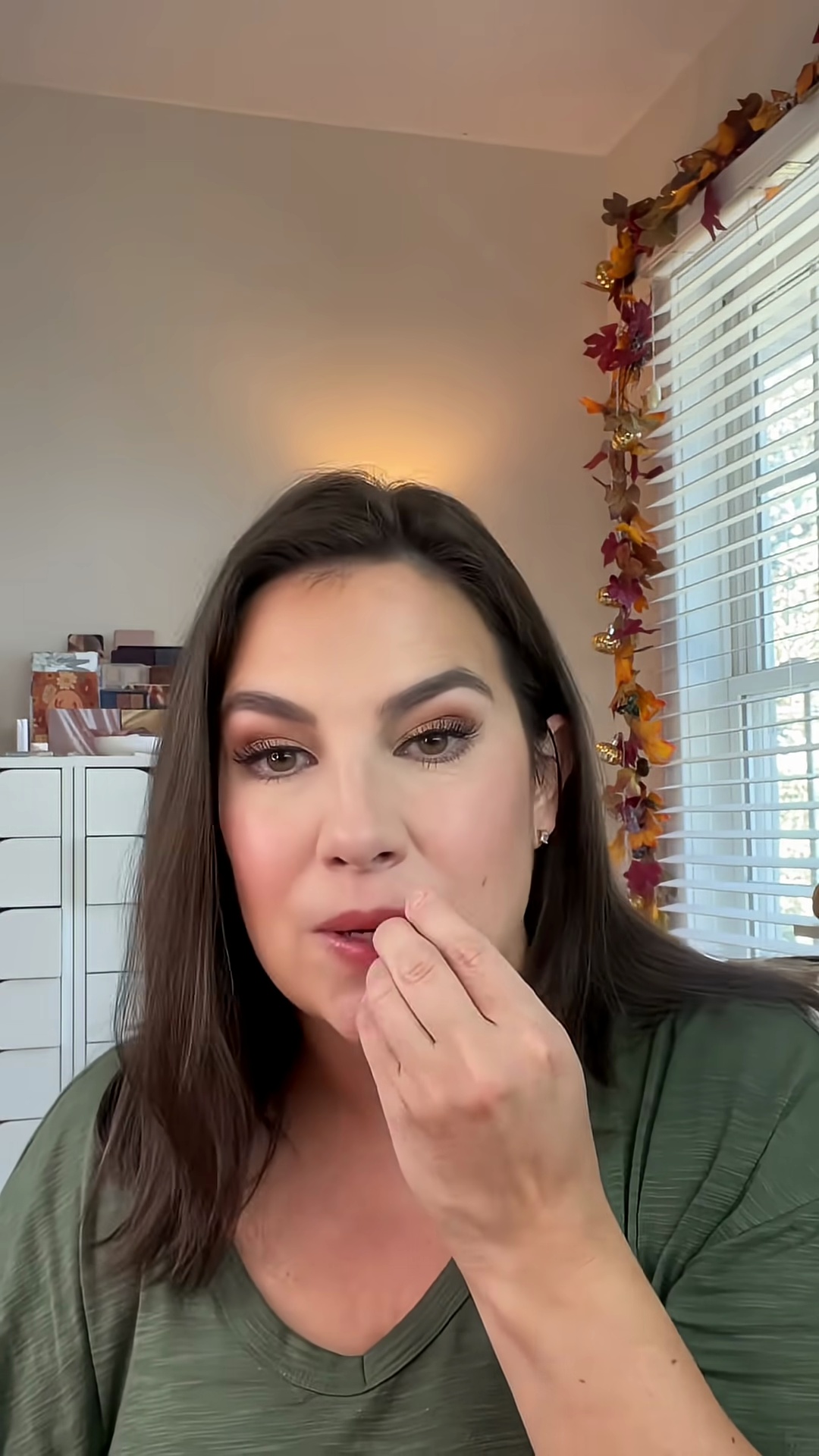 Emily applying the light pink hibiscus lip balm to her lips