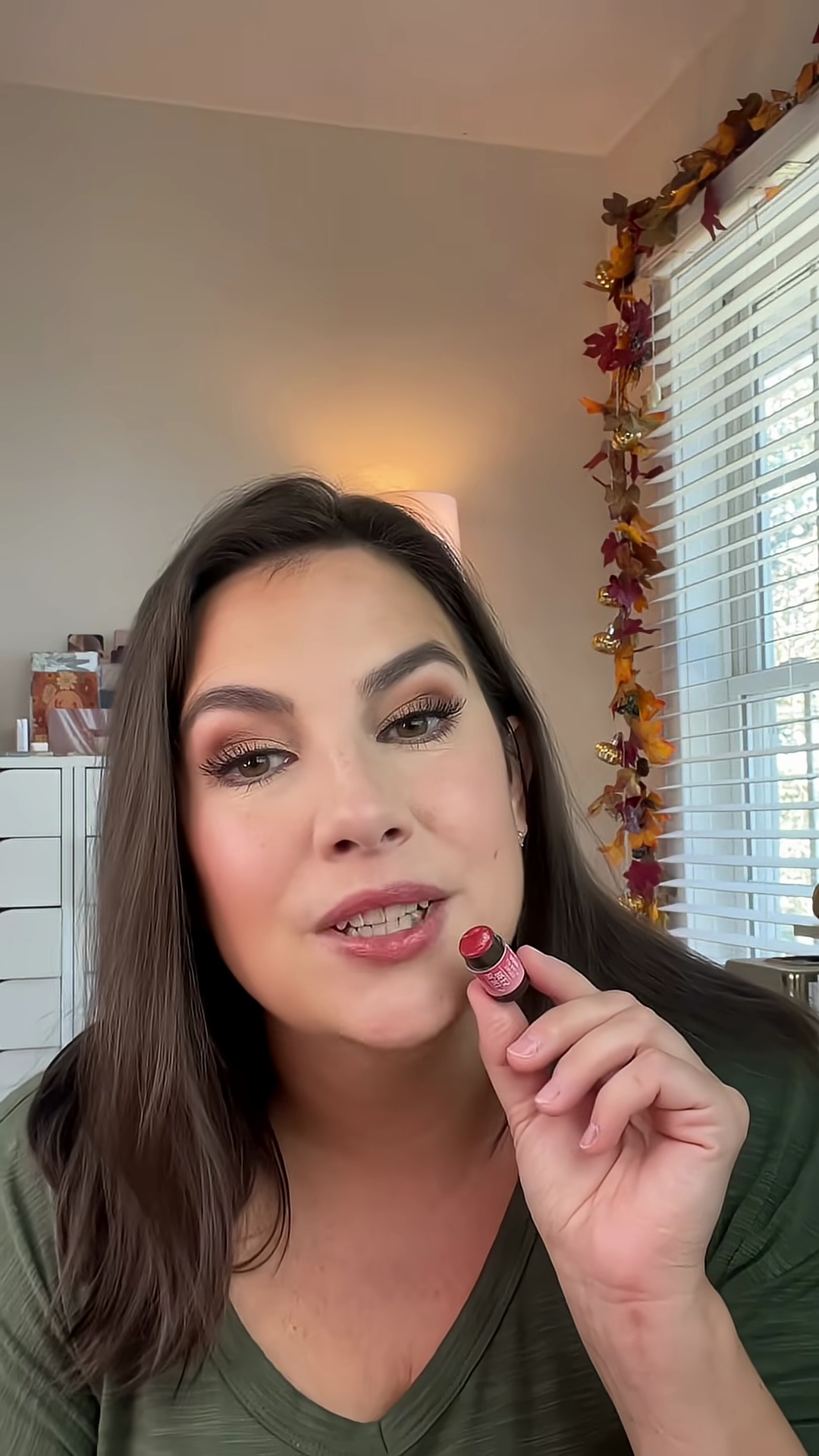 Red dalia lip balm applied showing its plum-tinted color