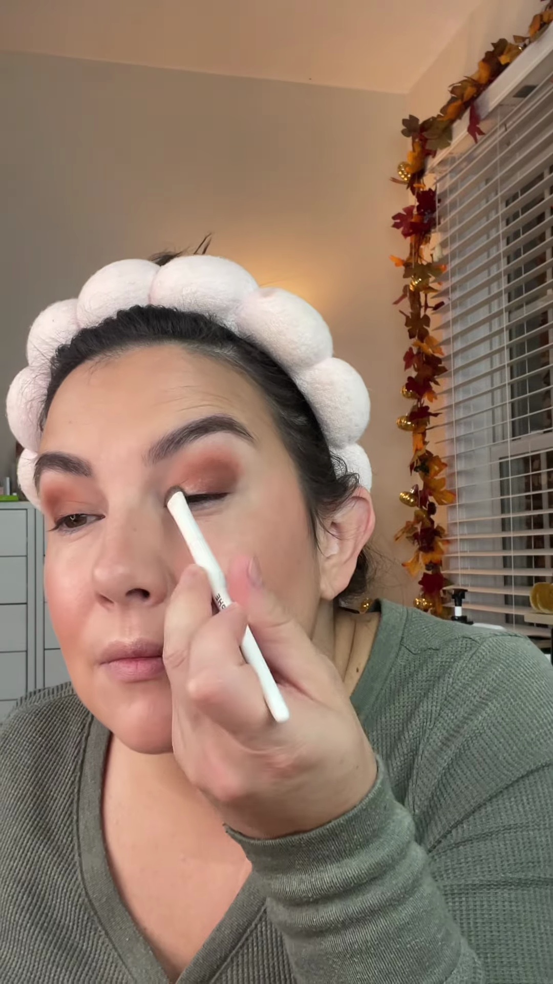 Shimmer eyeshadow being applied to inner lid with a small brush