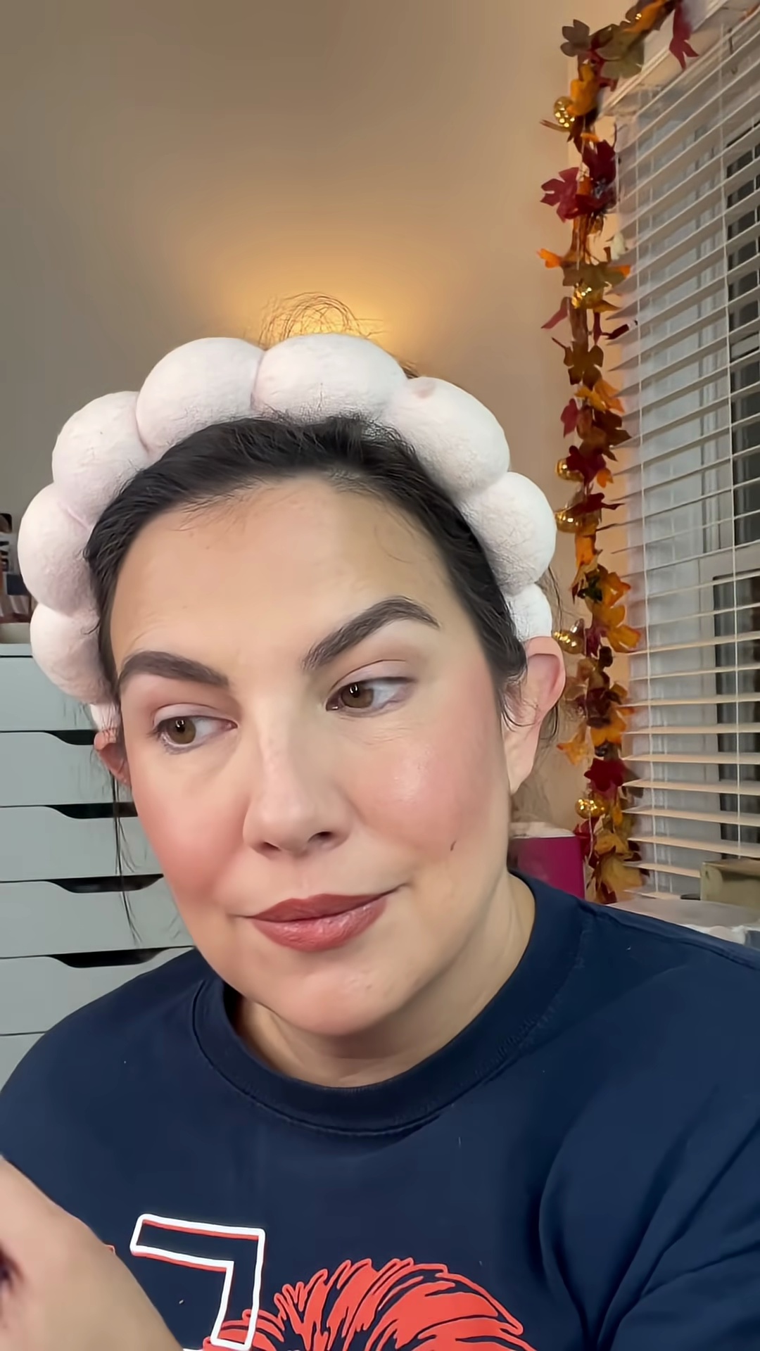 Emily Noel applying highlighter from Krice palette to cheekbones and cupid's bow