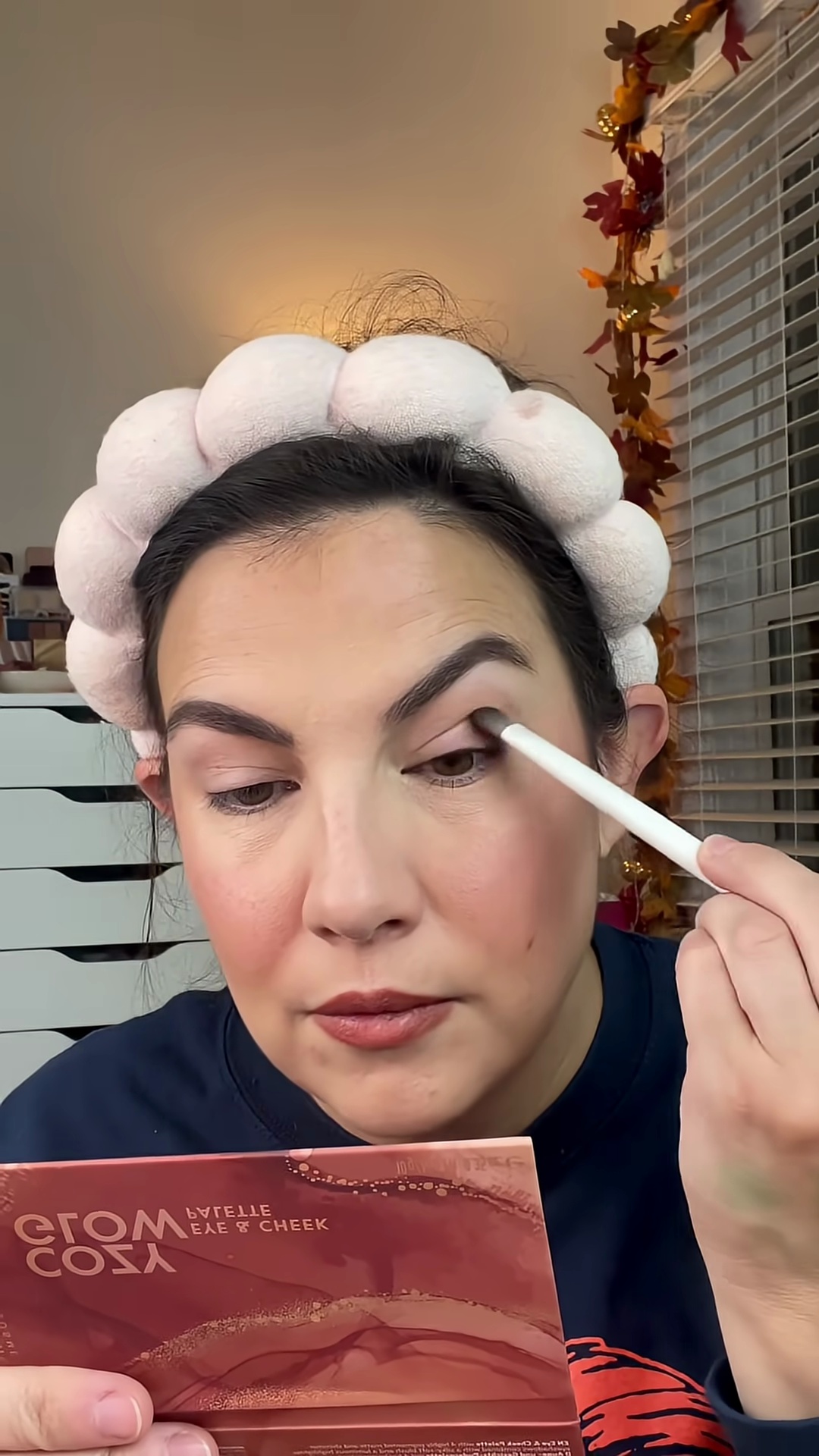 Emily Noel applying matte brown eyeshadow from Krice palette to eyelid