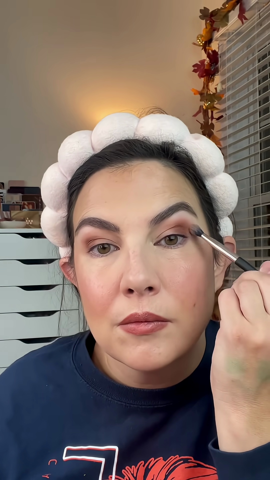 Emily Noel applying berry blush from palette to eyelids as eyeshadow