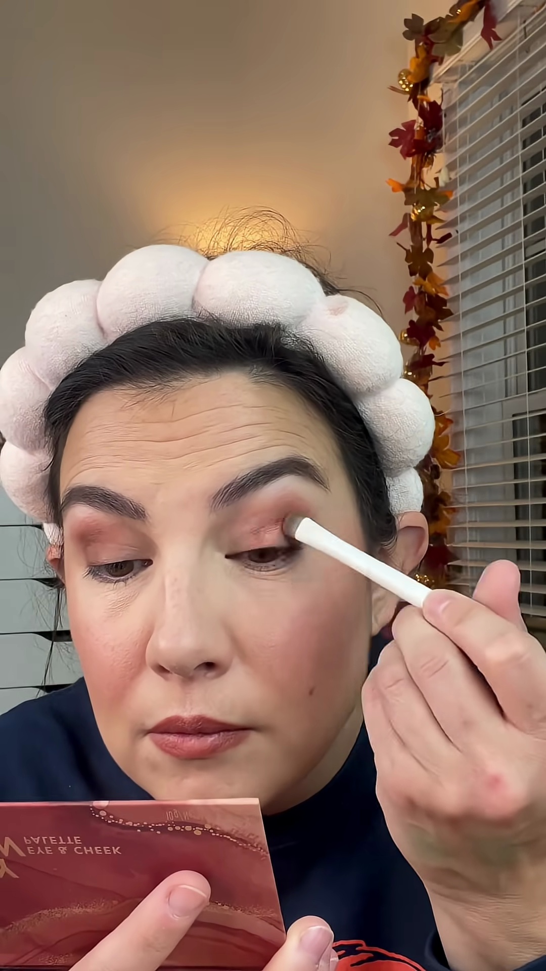 Emily Noel applying shimmer eyeshadow and highlighter to inner eye corners