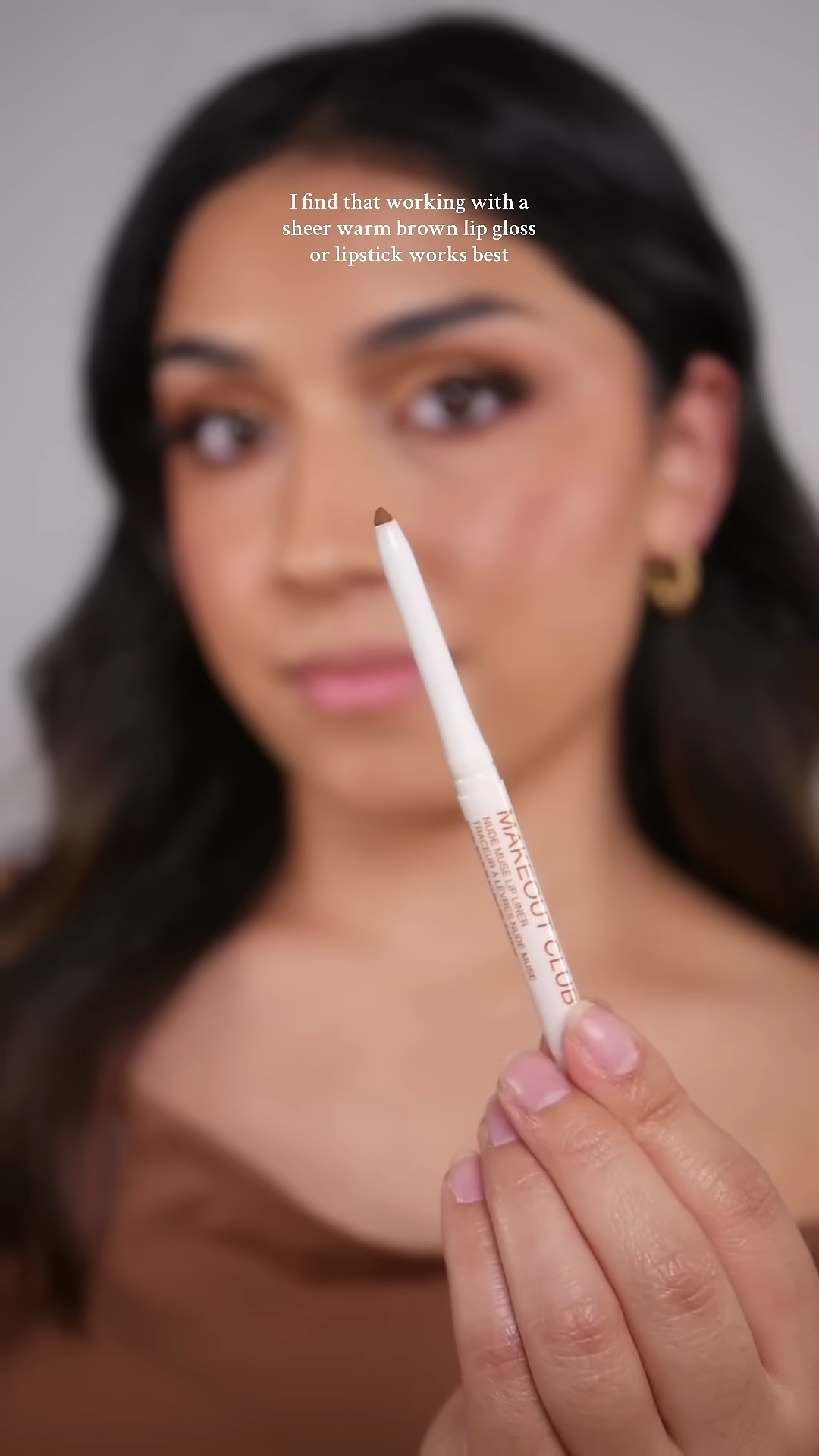 Close-up of brown eyeliner application on olive skin