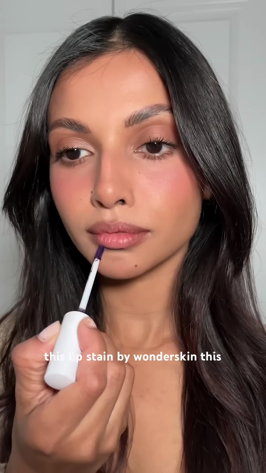 Creator Silvy Botha showing the Wonderskin lip stain tube in shade Bella