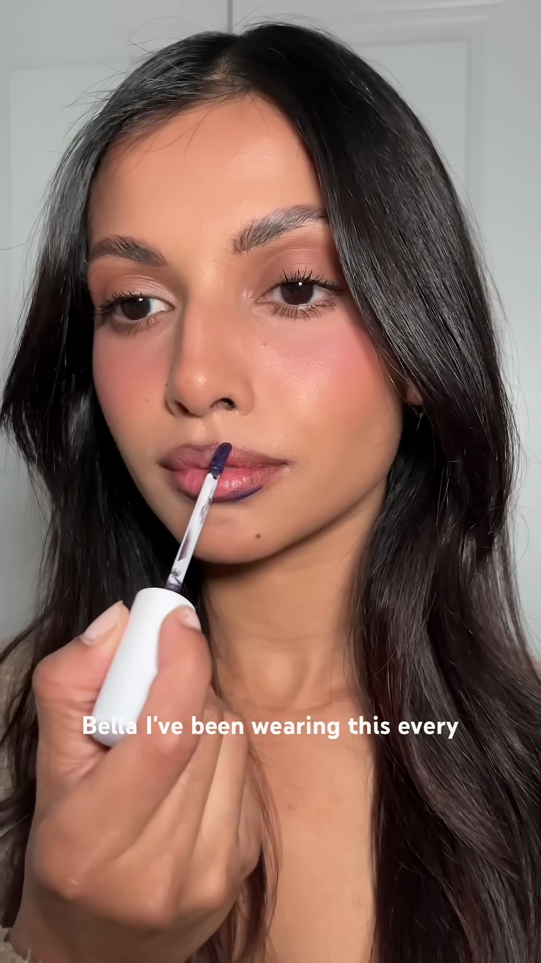 Close-up view of Wonderskin lip stain in shade Bella on medium brown olive skin