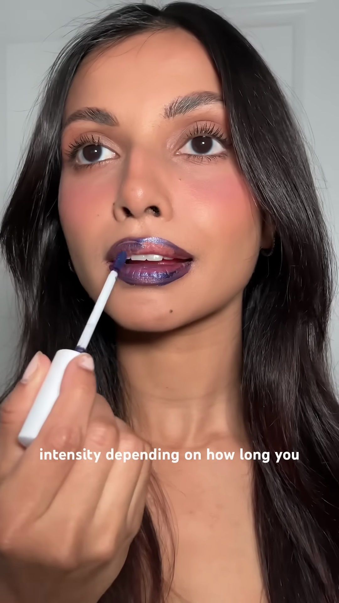 Silvy applying the lip stain to show its buildable coverage